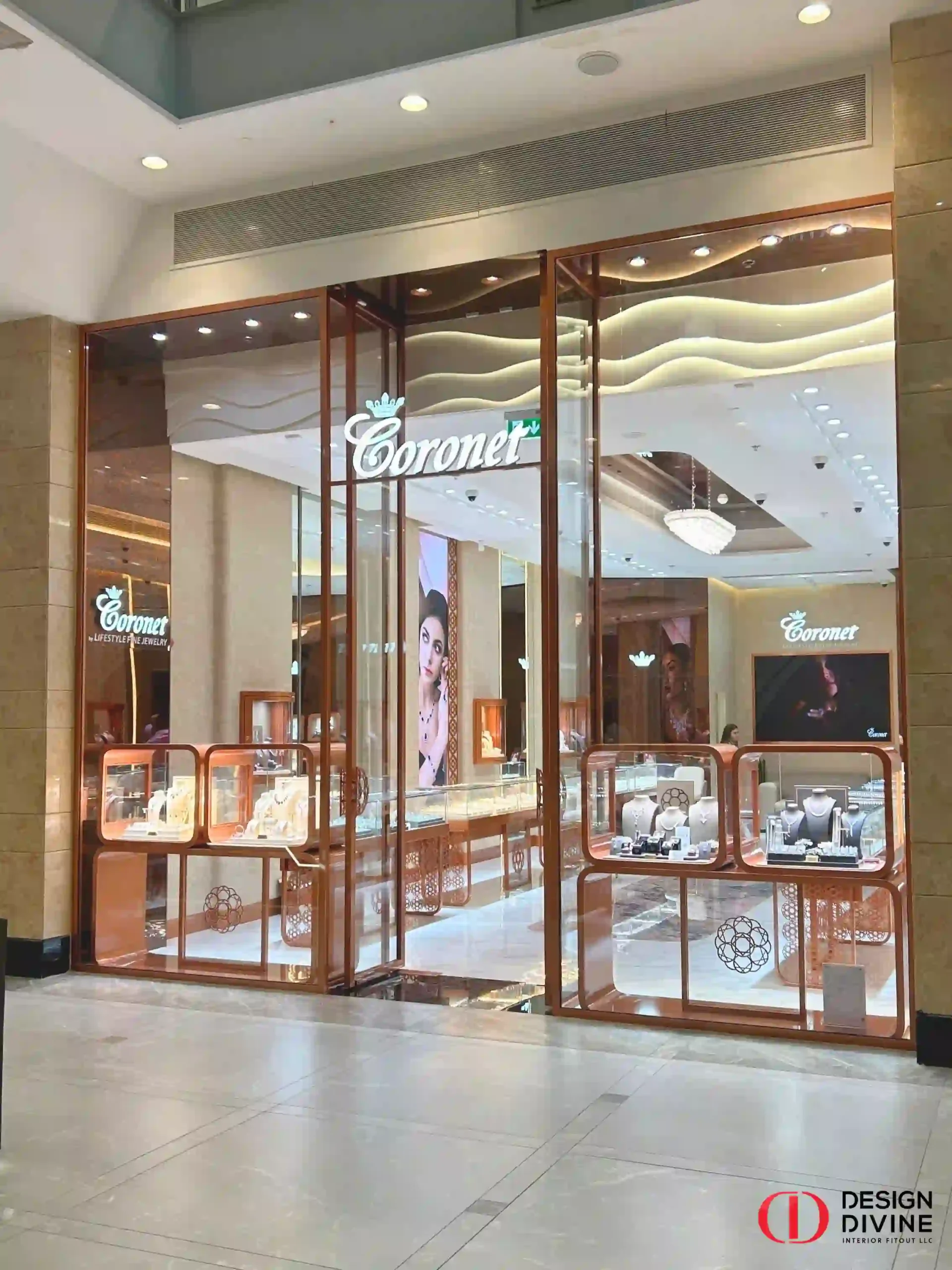 Full exterior view of the luxury Coronet by Lifestyle Fine Jewelry boutique facade at Abu Dhabi Mall, featuring full-height rose gold glass framing and custom window displays by Design Divine Interior Fitout LLC.