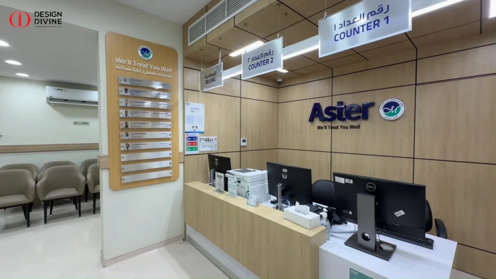 Aster Clinic reception counter with timber-effect paneling and bilingual signage, Al Satwa Dubai